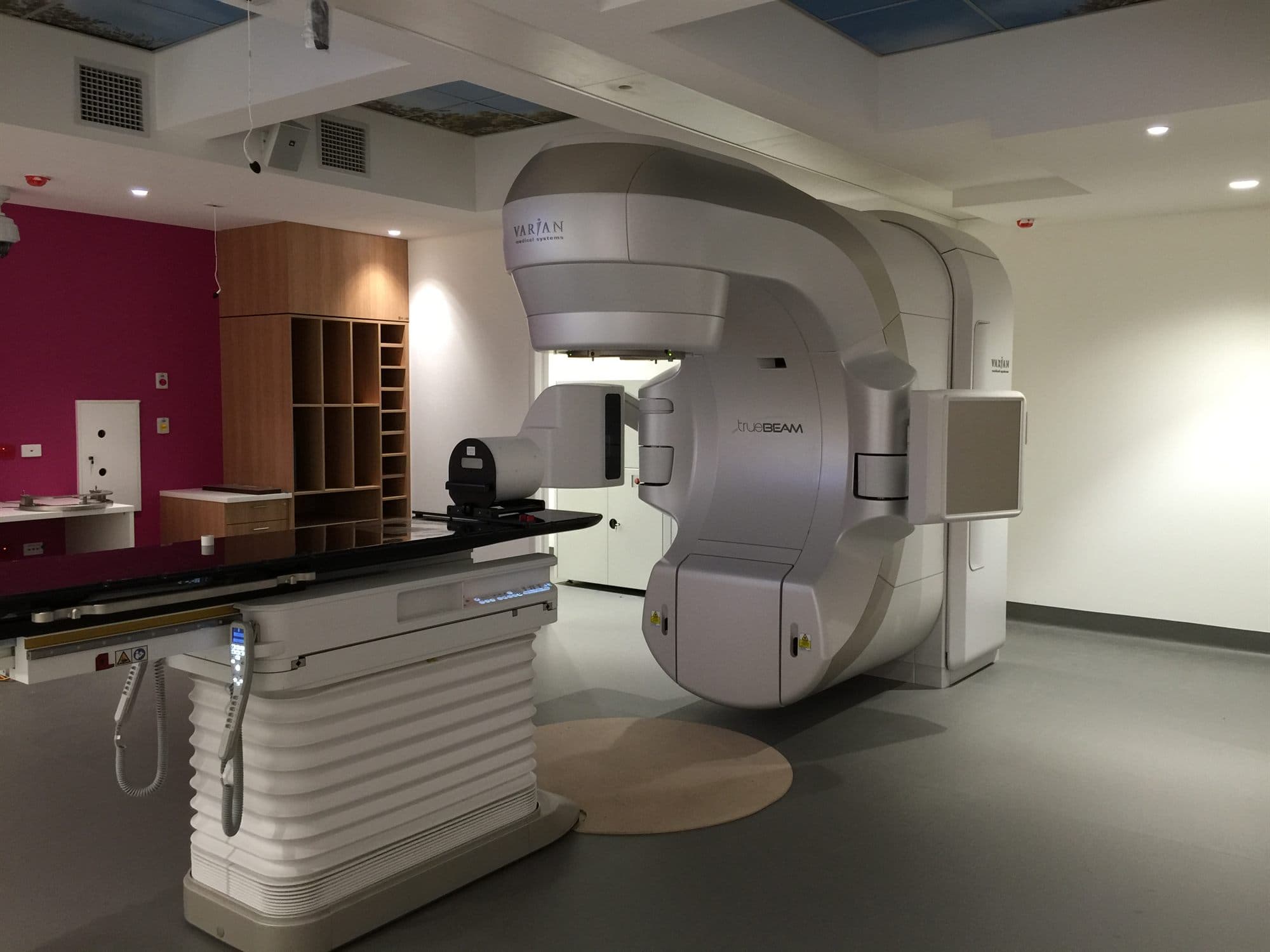 A radiation therapy machine and treatment couch in a finished treatment room.